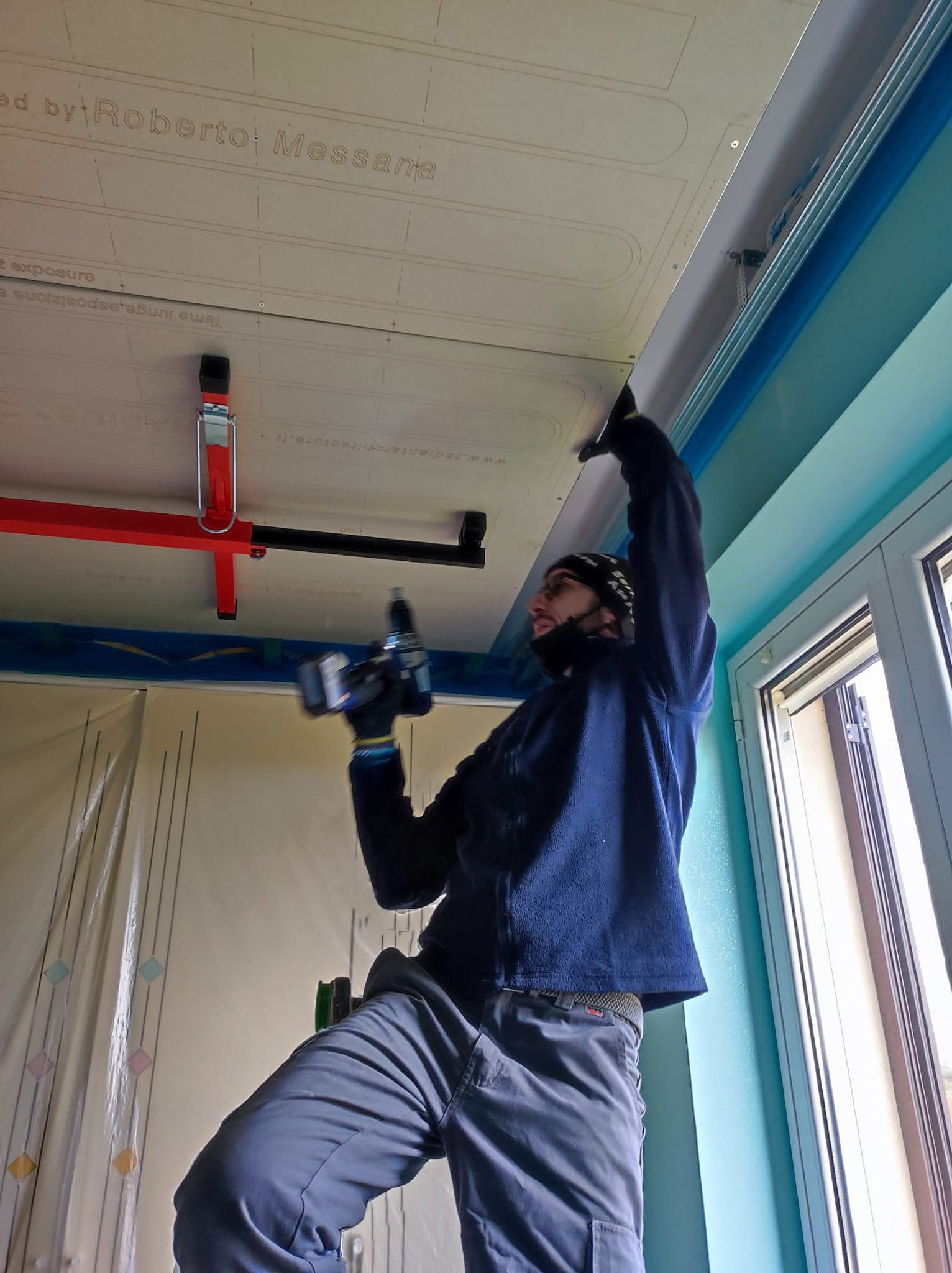 Operatore durante il fissaggio dei pannelli radianti a soffitto